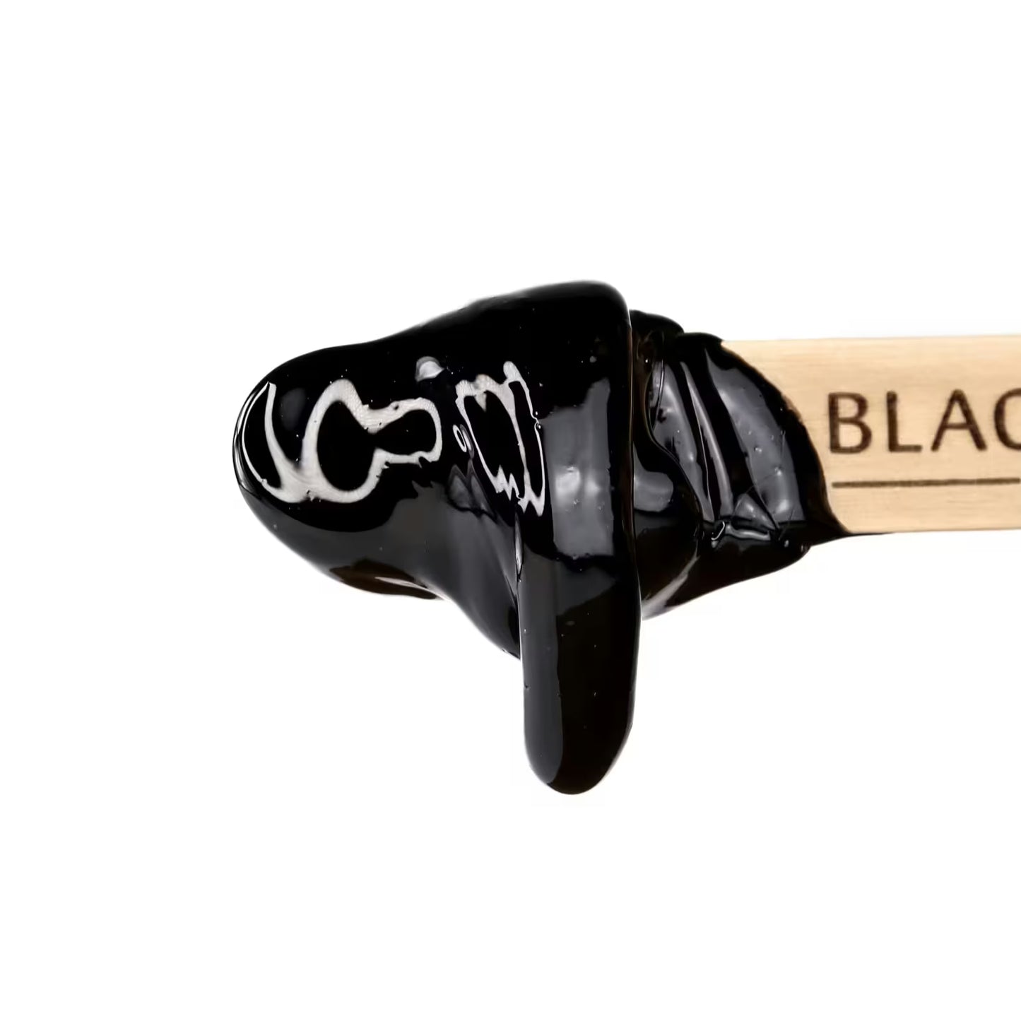 A wooden stick with BLACK partially visible is dipped in Black Coral Hard Wax by Black Coral Wax USA, showcasing a glossy, smooth finish. The stripless wax promises long-lasting hair removal and stands out against a white background.
