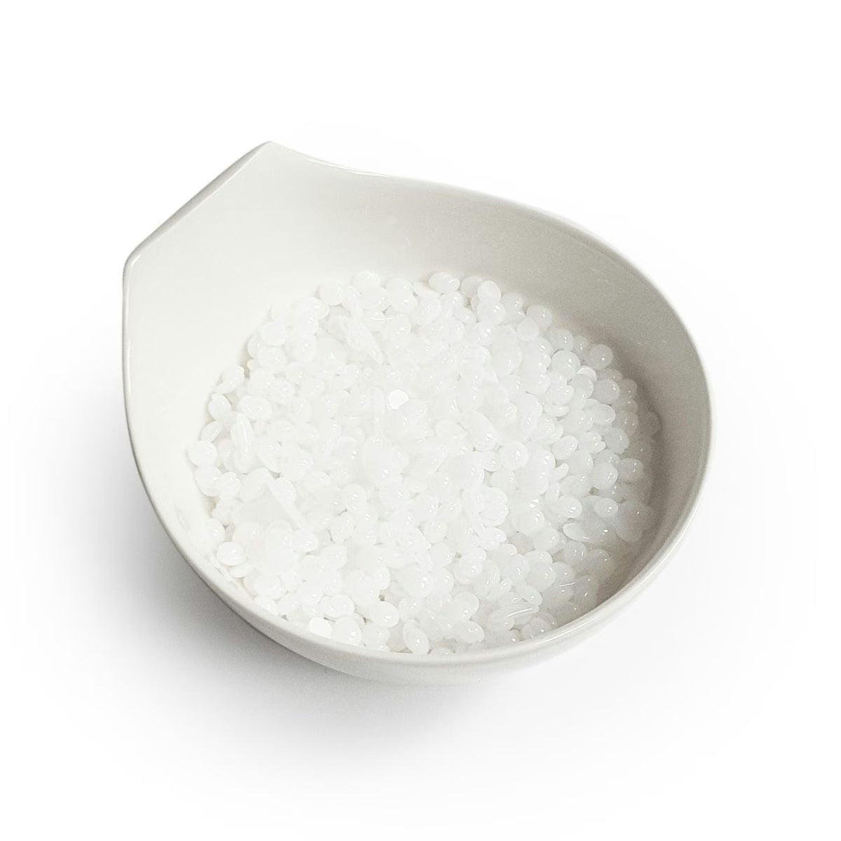 White bowl filled with Mae Mae hard wax pearls on a white background