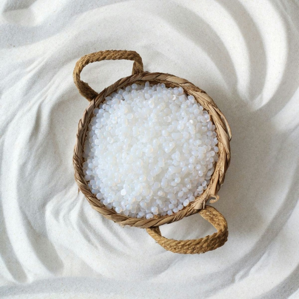 Woven basket with Mae Mae hard wax beads on a textured white surface