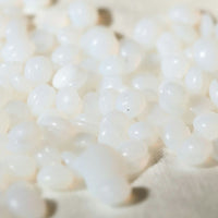 Close-up of white Mae Mae hard wax pearls on a light background